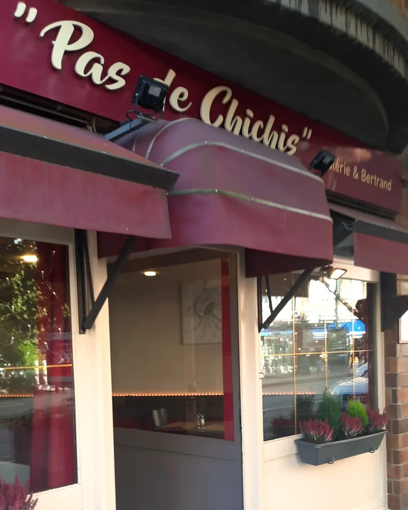 Front of the Pas de Chichis restaurant, burgundy awnings and the sign “Valérie & Bertrand”