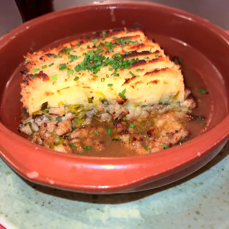 Parmentier gratiné servi dans son plat en terre cuite